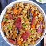 Chinese sausage rice with carrots and mushroom in a bowl.
