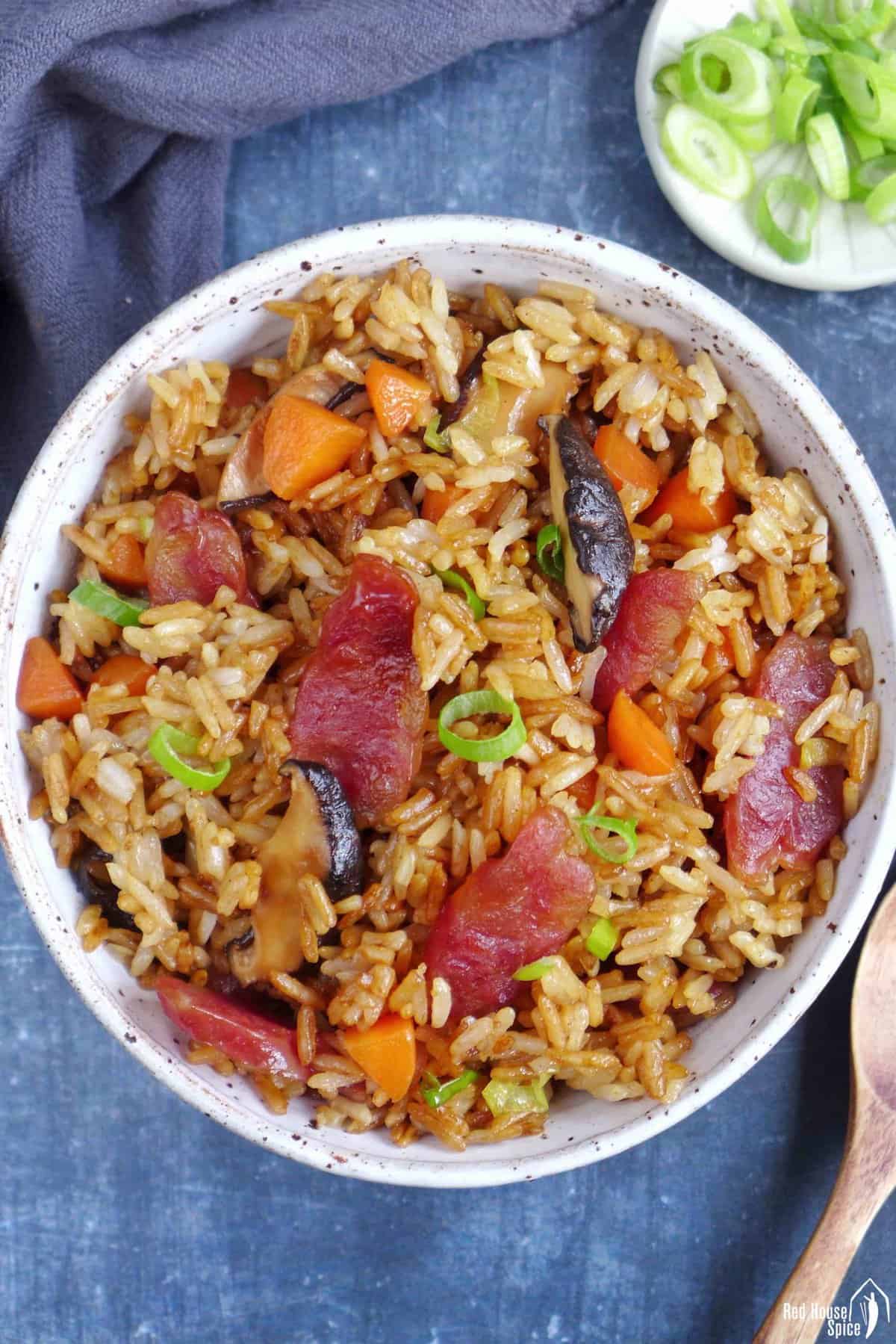 Chinese sausage rice with carrots and mushroom in a bowl.