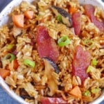 Chinese sausage rice with carrots and mushroom in a bowl.