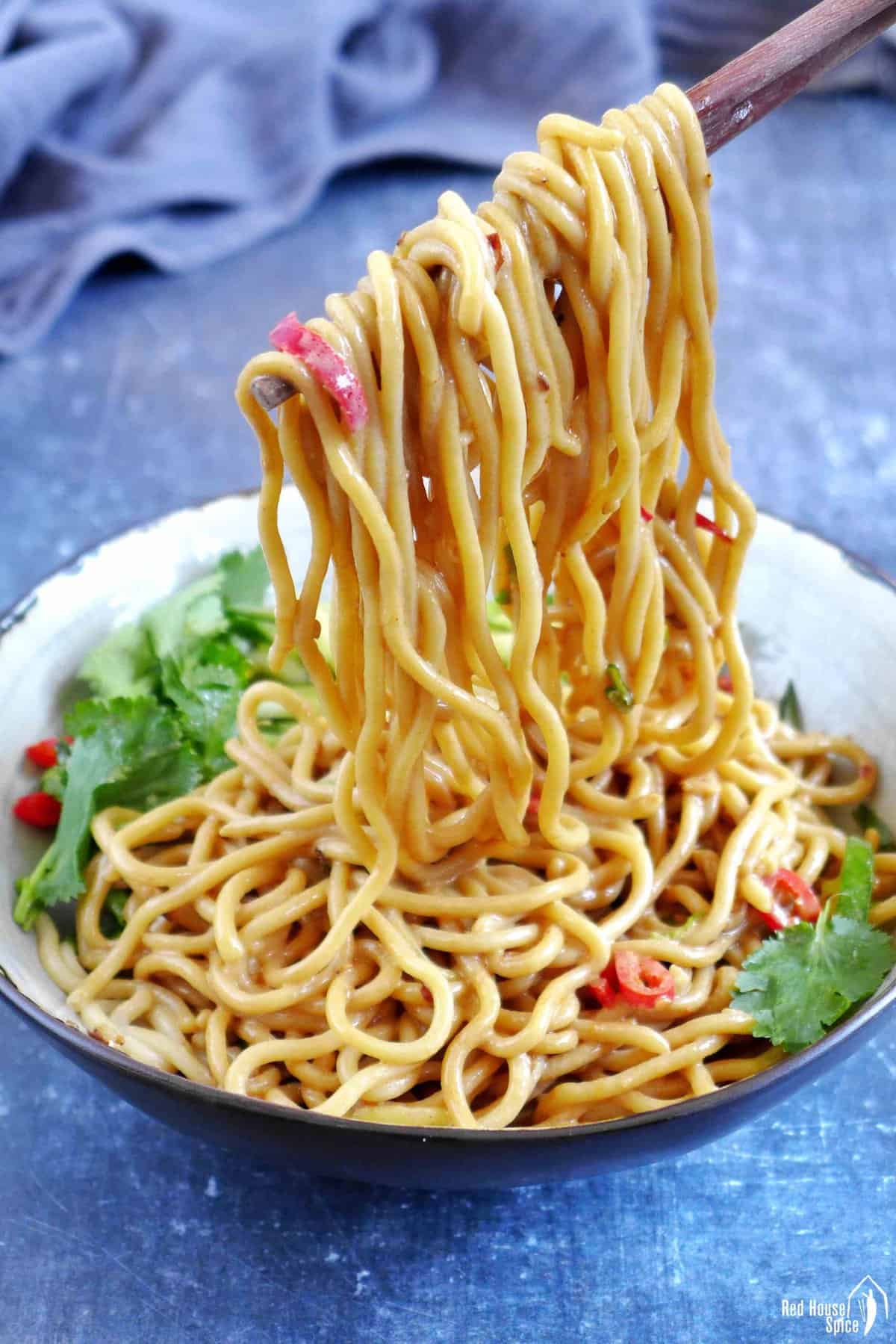 Pulling up Chinese sesame noodles with chopsticks.
