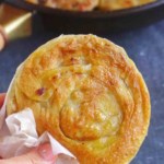 A Chinese crispy beef flatbread held by a hand.
