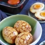tea eggs in marinade, peeled tea eggs and halved tea eggs.