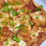 tofu omelet garnished with scallions with overlay text that says chinese tofu omelet.