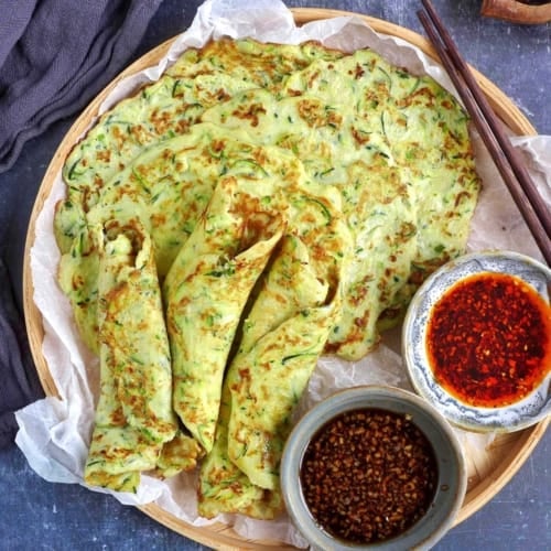 zucchini pancakes on a tray with sauces.