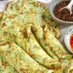 zucchini pancakes on a tray with sauces.