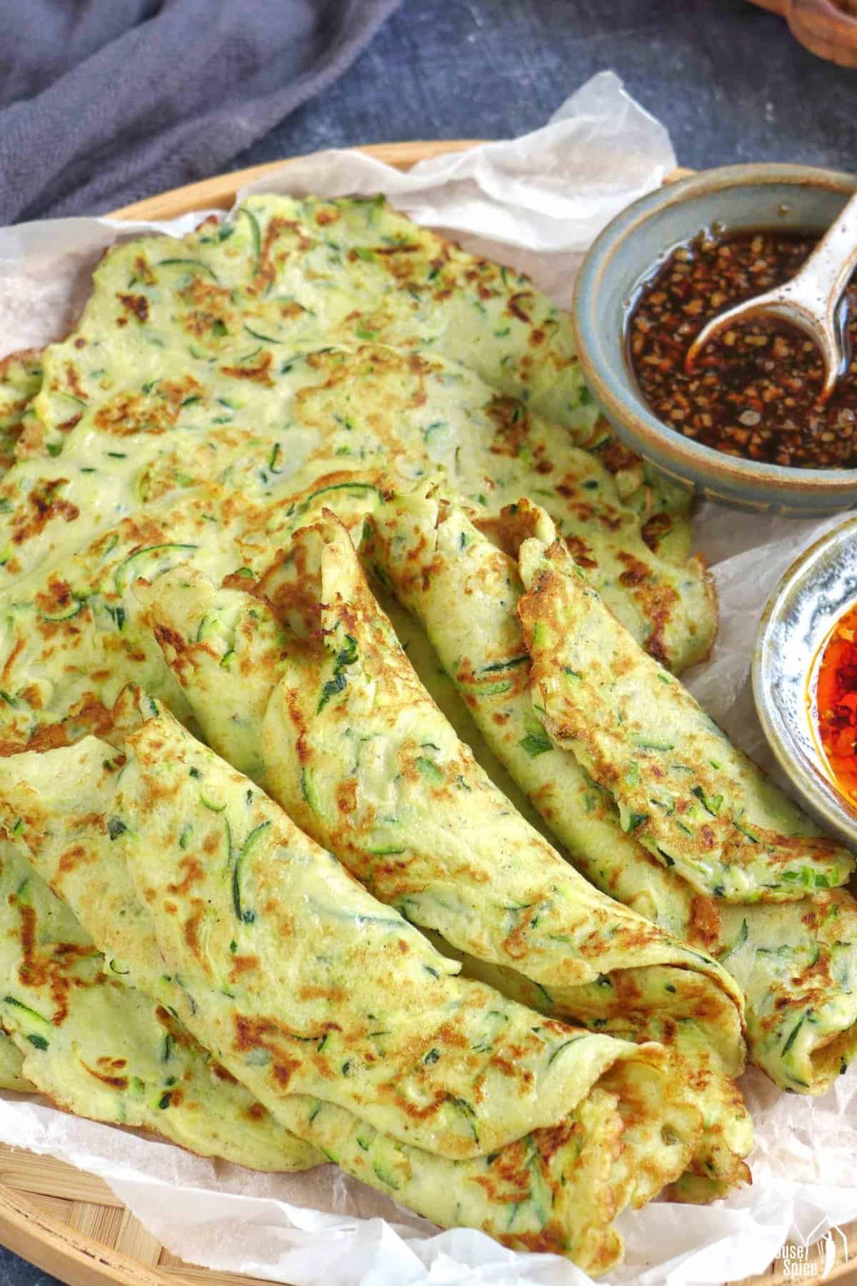 zucchini pancakes on a tray with sauces.