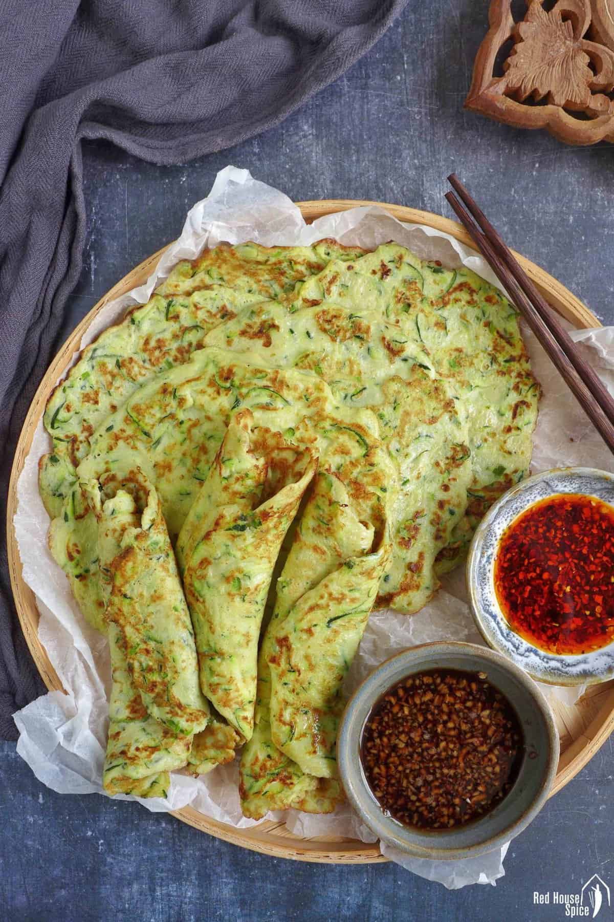 zucchini pancakes on a tray with sauces.