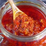scooping out chiu chow chili oil from a jar.