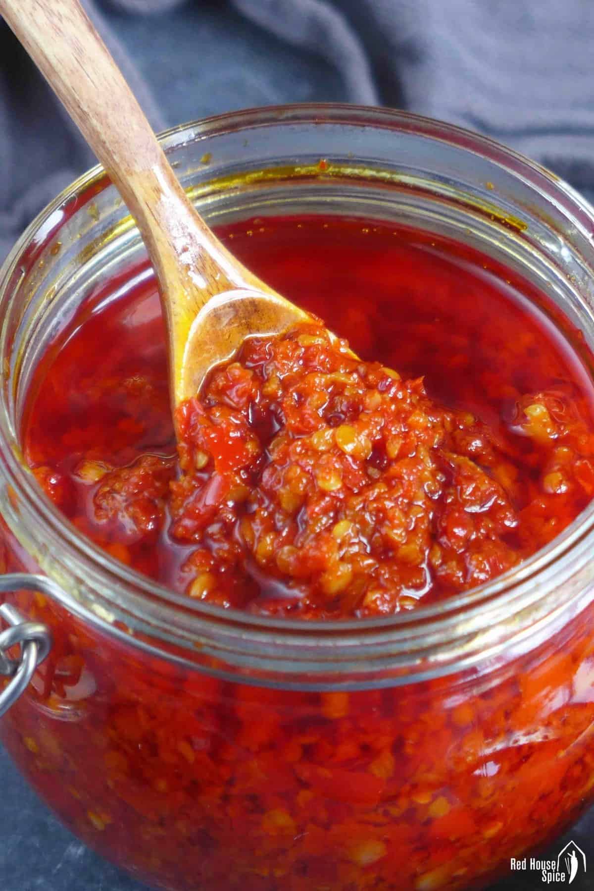 scooping out chiu chow chili oil from a jar.