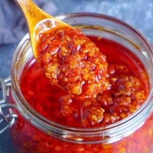 scooping out chiu chow chili oil from a jar.