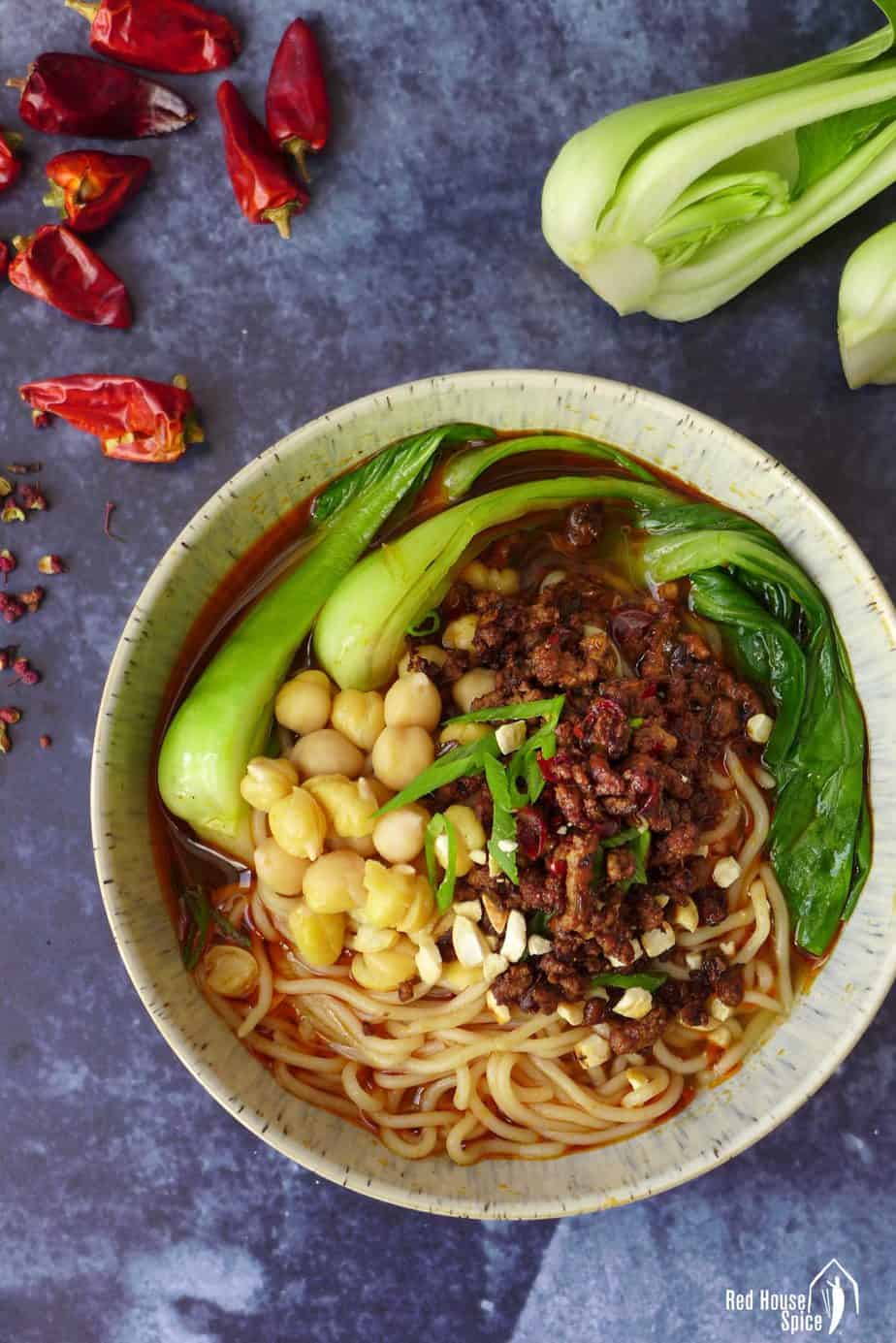A bowl of Chongqing noodles topped with minced meat and chickpeas.