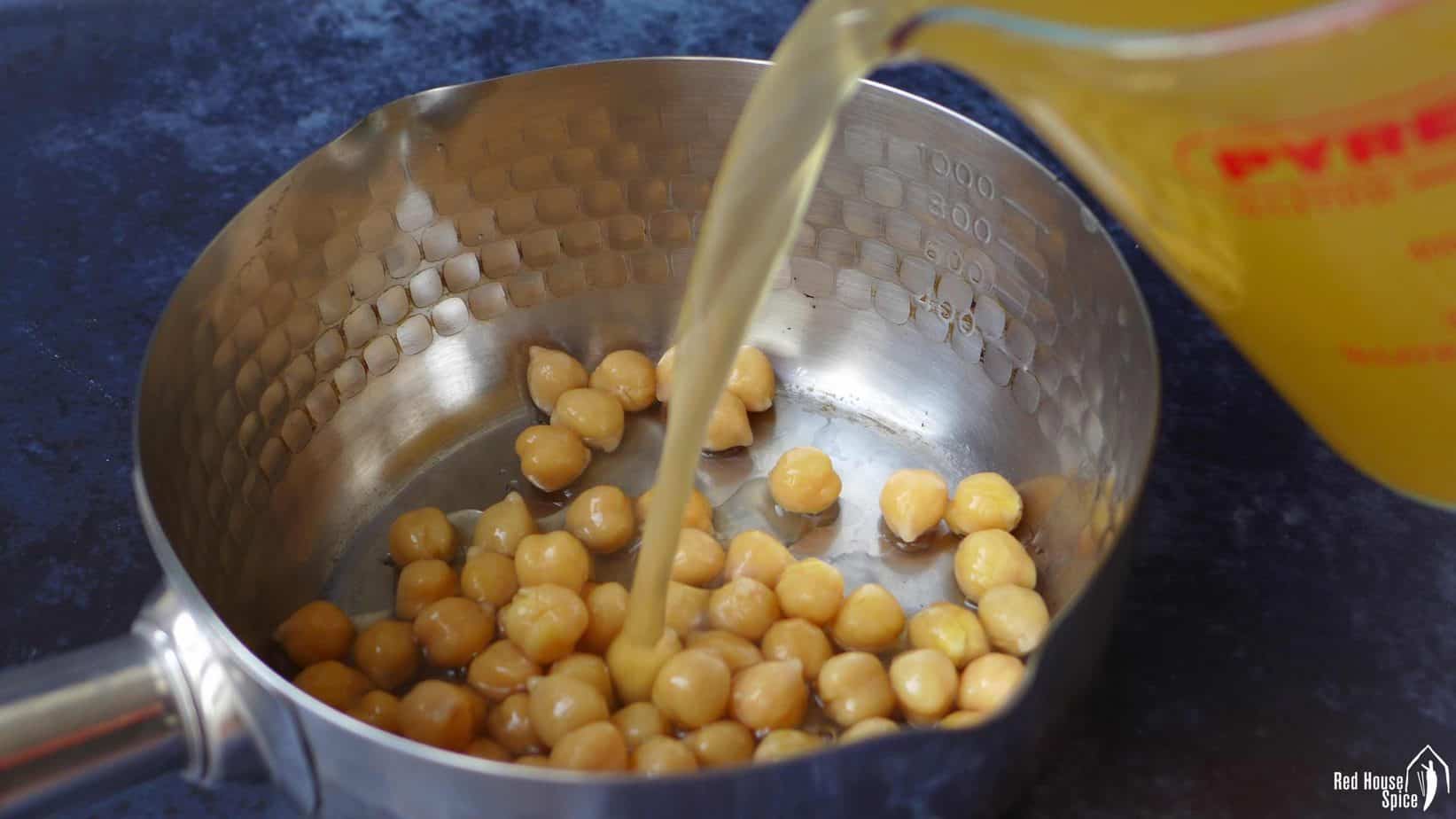 Chicken stock poured over some chickpeas.