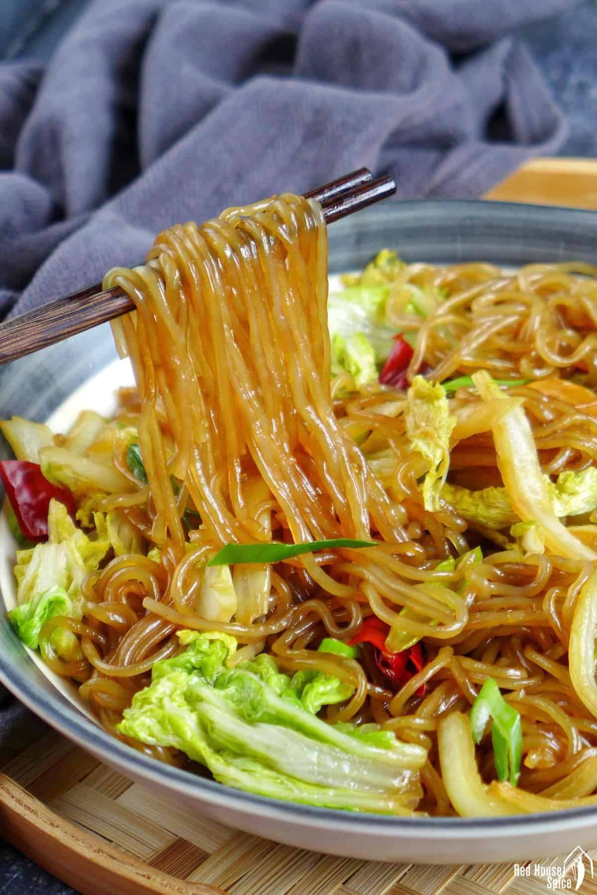 chopsticks lifting glass noodles