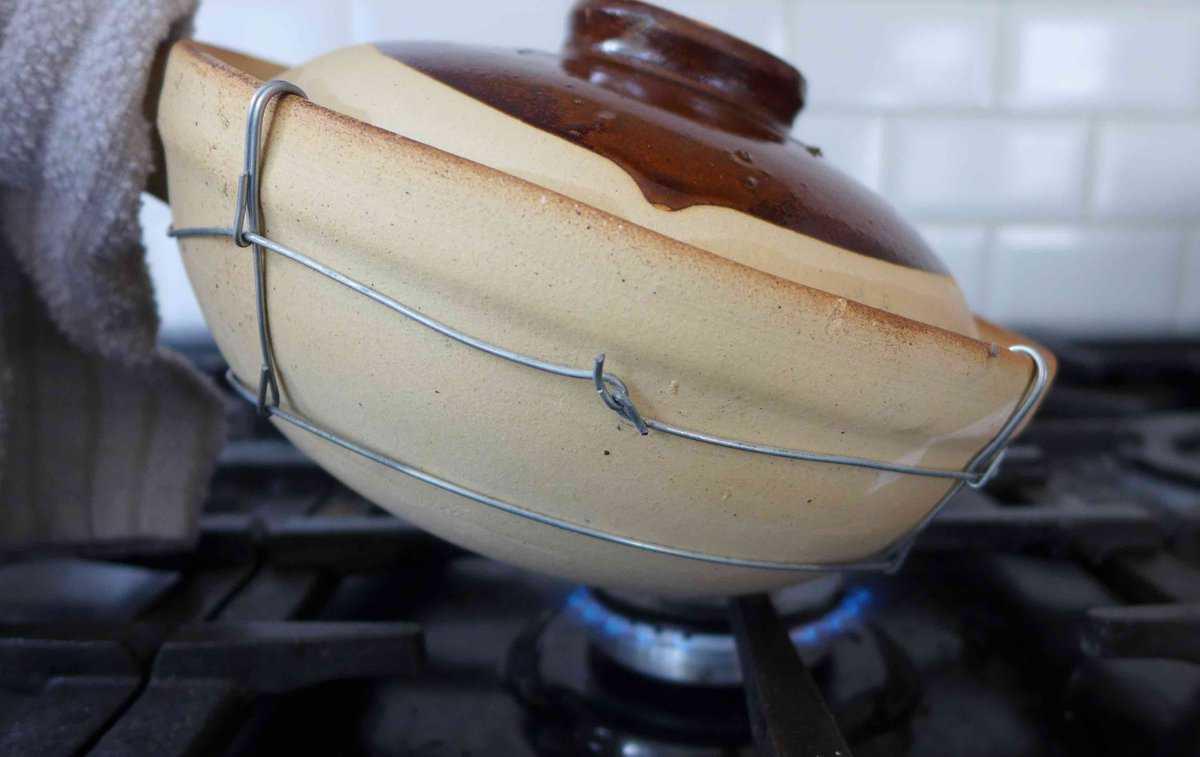tilted clay pot over gas cooker.