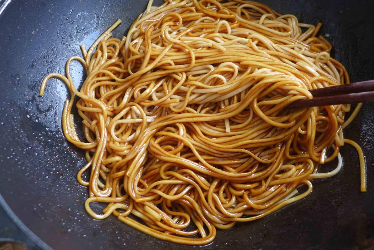 mixing sauce with noodles.