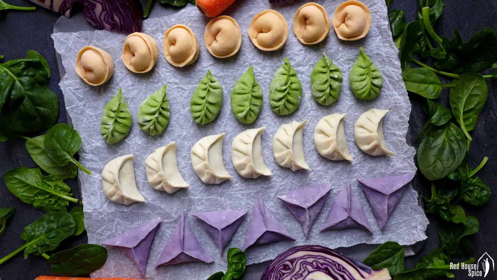 Lines of dumplings in white, green, orange and purple colour