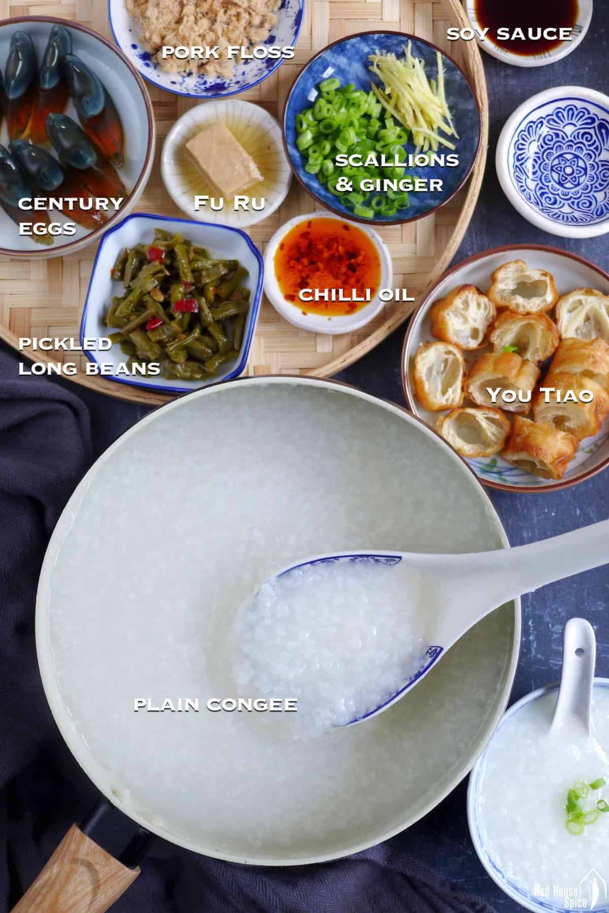 A pot of congee with different types of toppings on the side