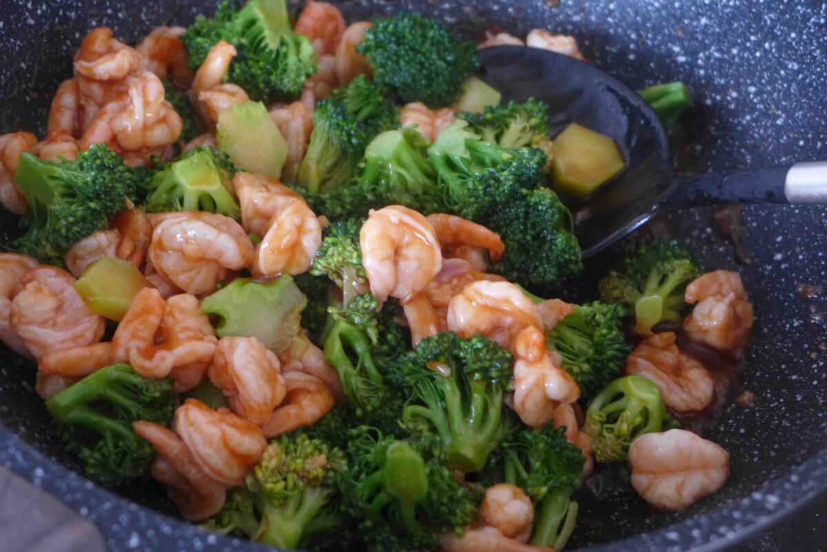 stir-frying shrimp and broccoli.