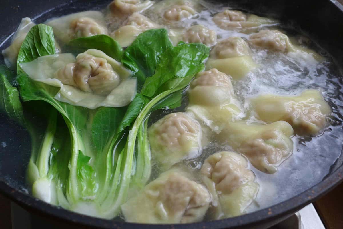 wontons and Bok Choy in boiling water.