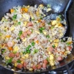 frying Yangzhou fried rice in a wok.