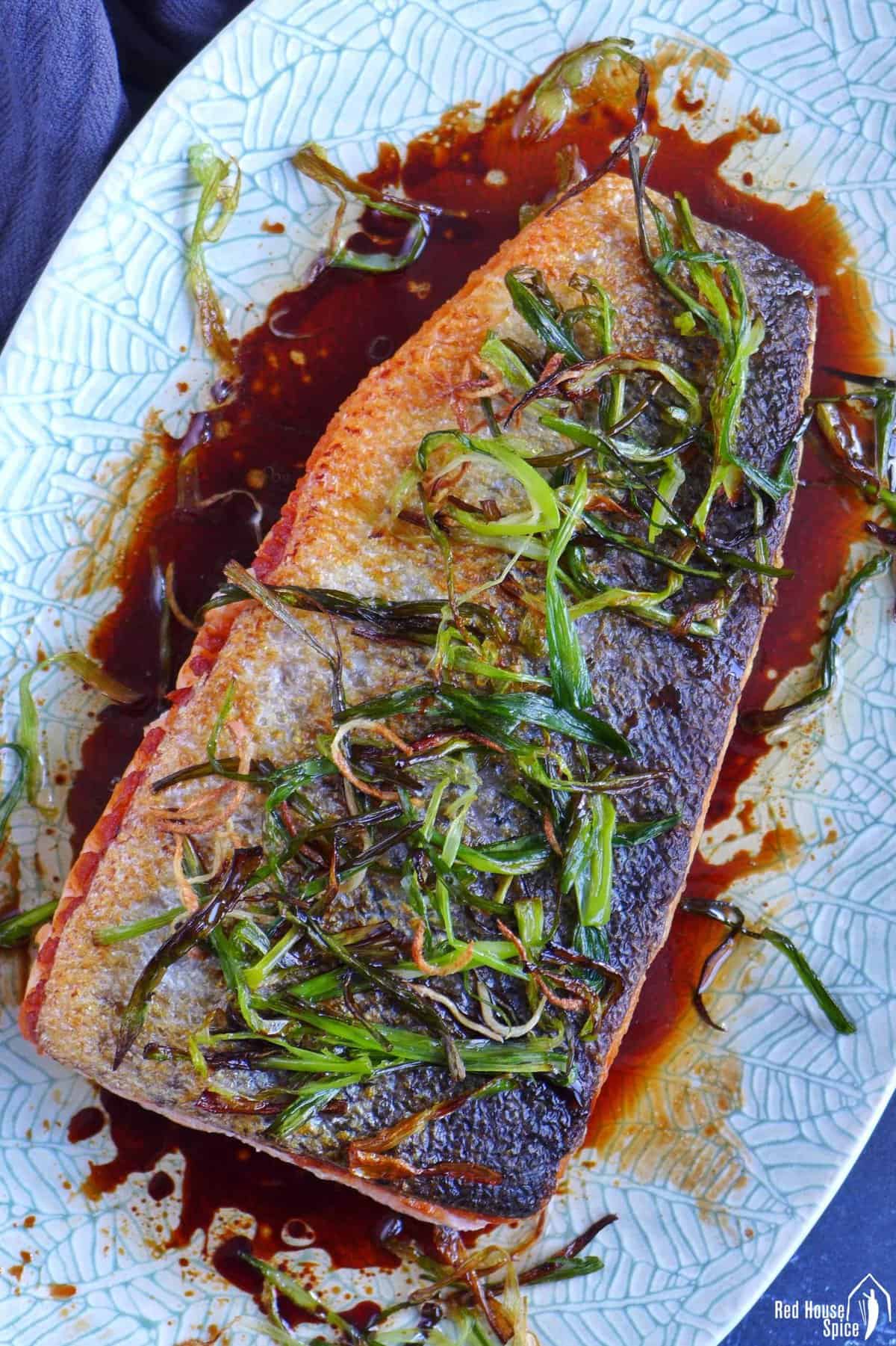 pan-fried salmon with fried scallions, ginger and a soy sauce dressing.