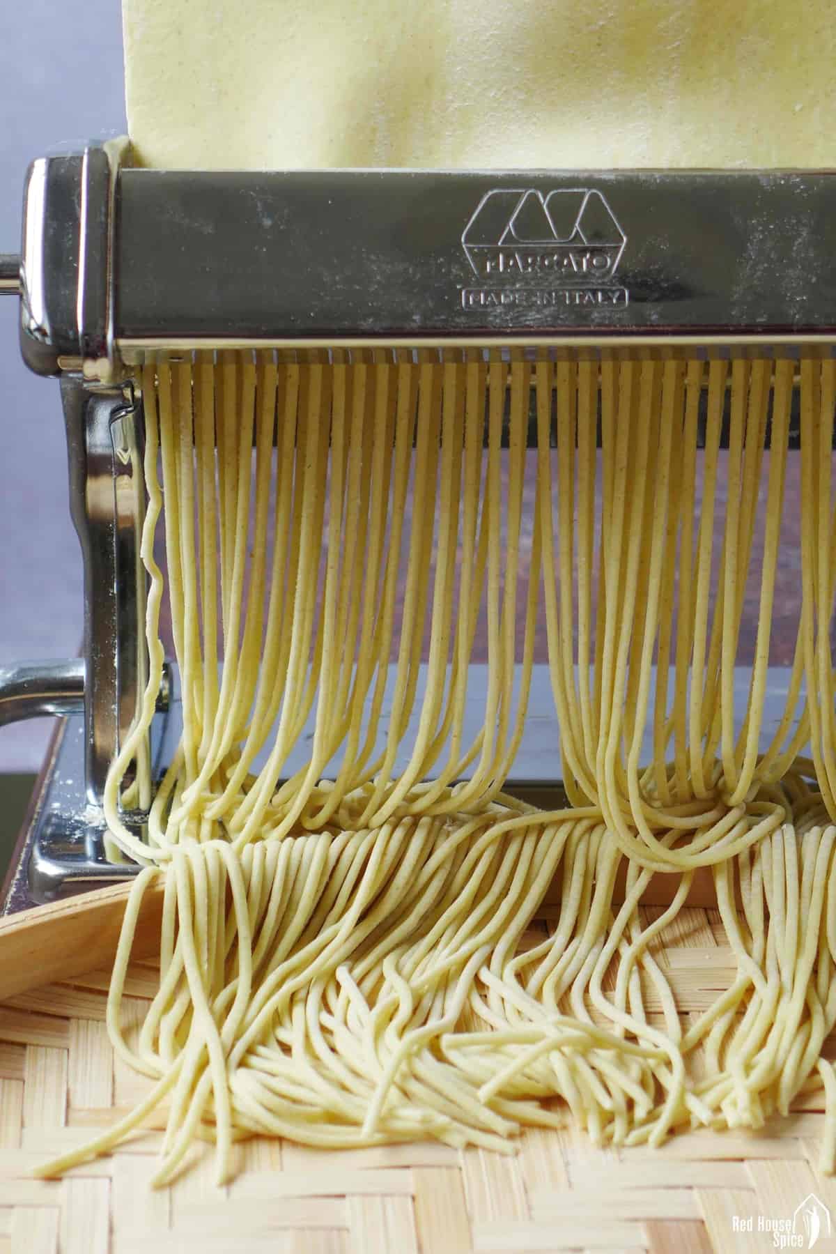 Cutting dough sheet into round noodles through a pasta cutter