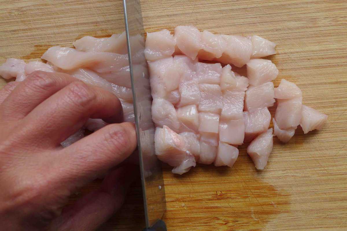 cutting chicken into small pieces.