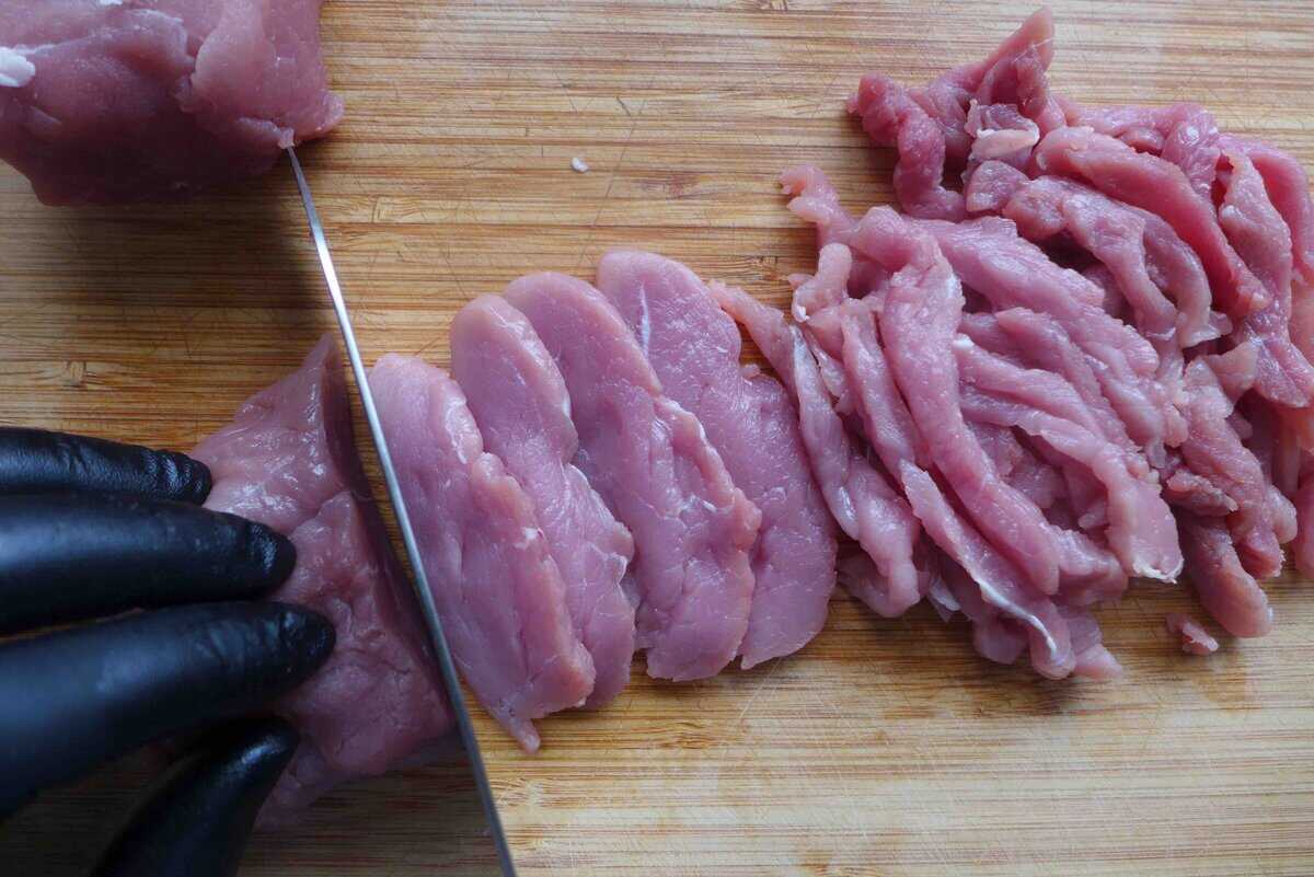 cutting pork into long strips.