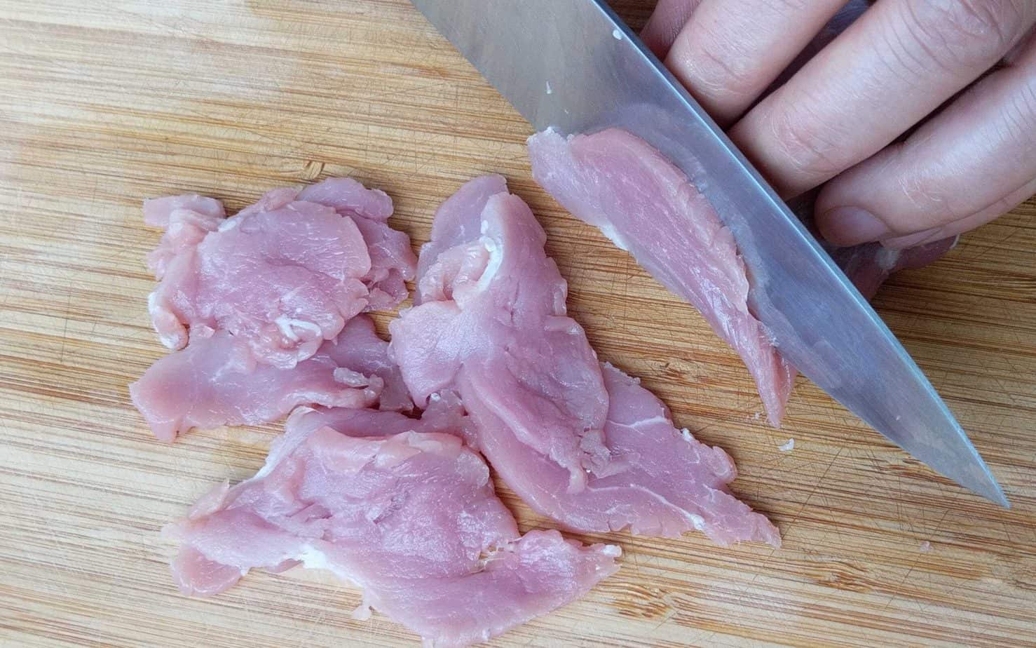 Slicing pork into thin pieces
