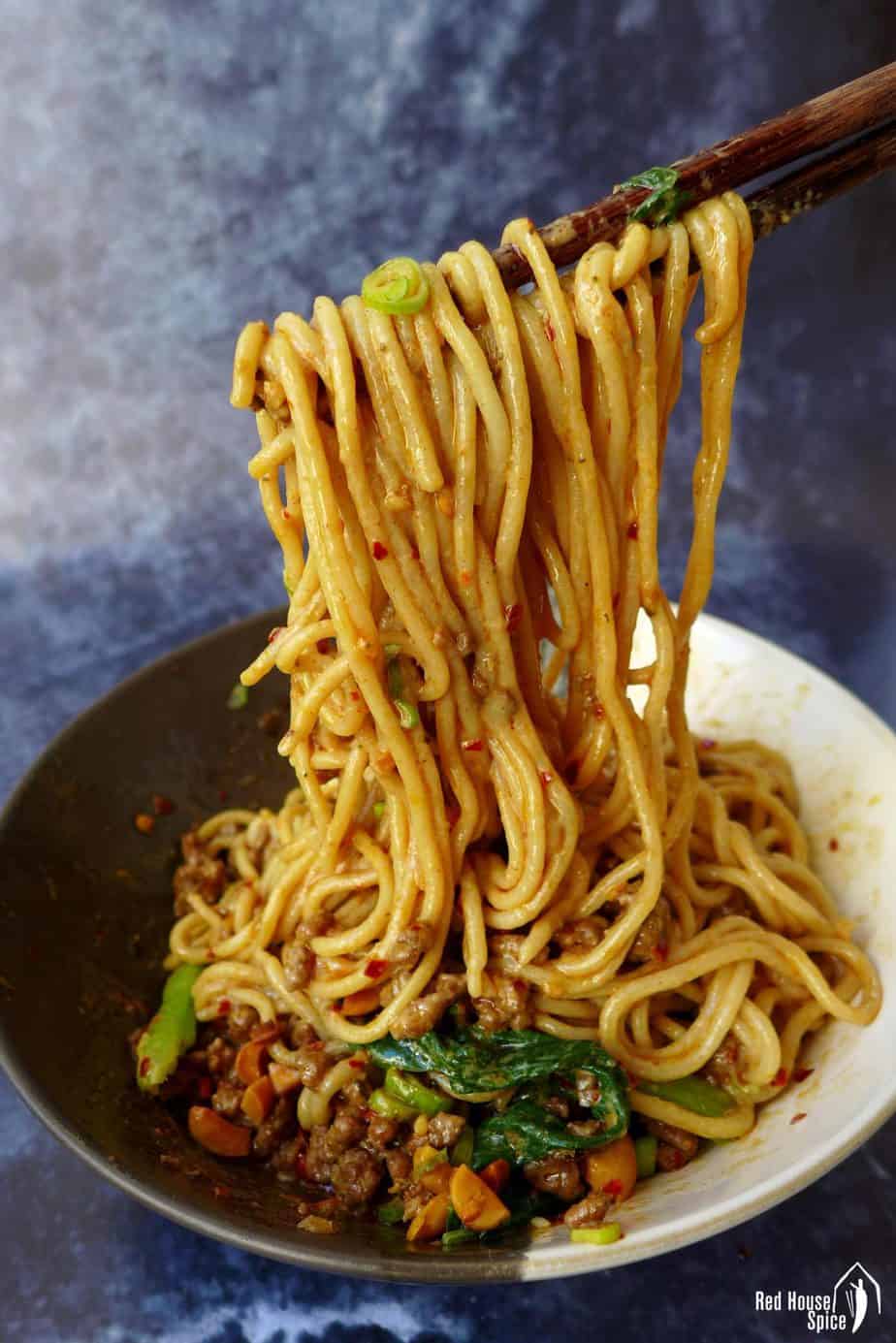 Dan Dan noodles lifted by chopsticks