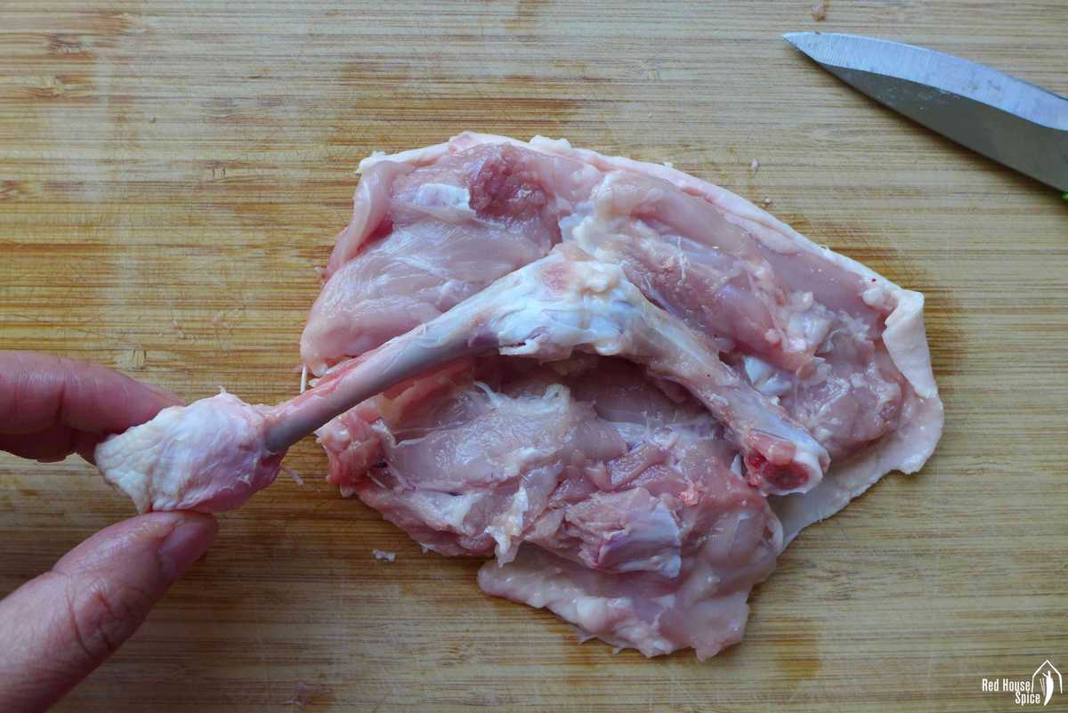 cutting the bone off a chicken leg
