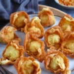 deep-fried wontons on a plate with chili oil on the side.