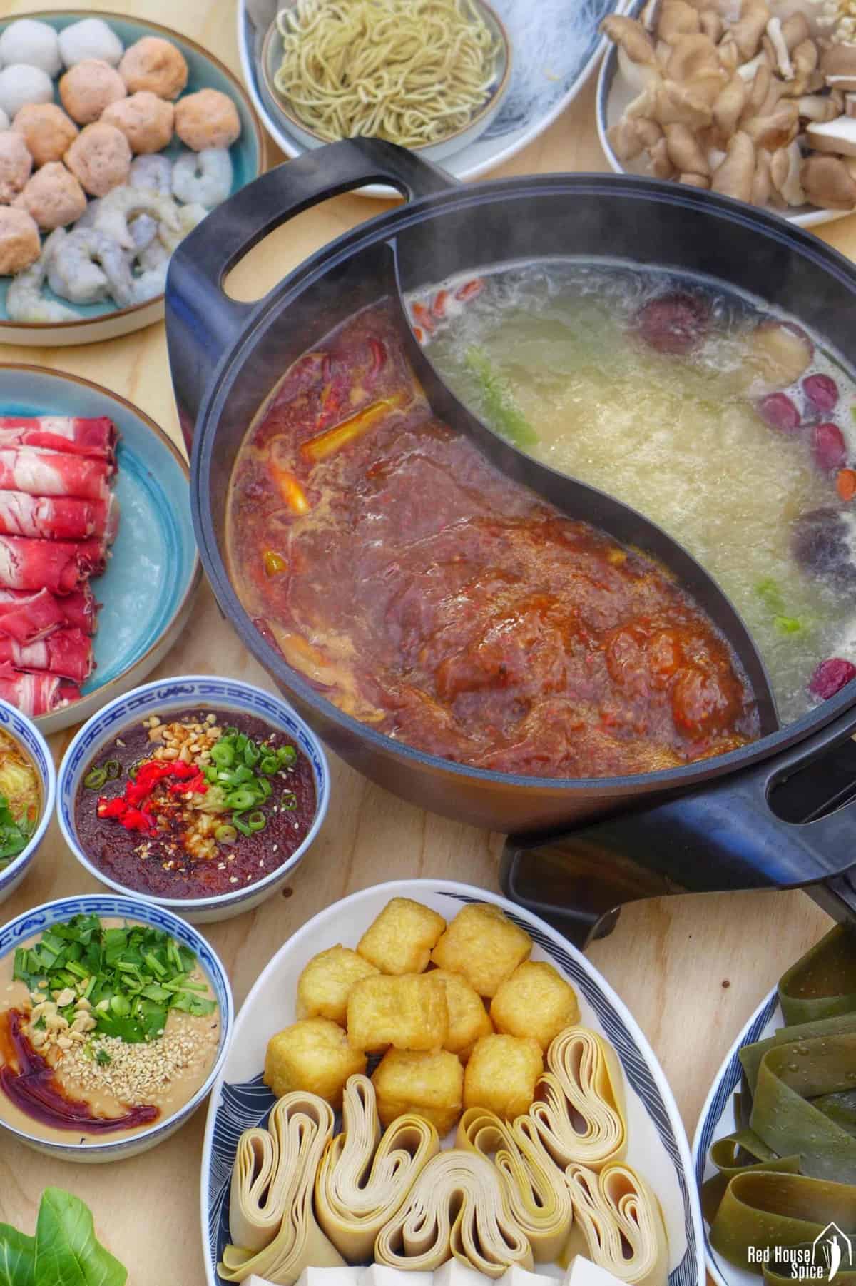 boiling hot pot with raw ingredients at the side