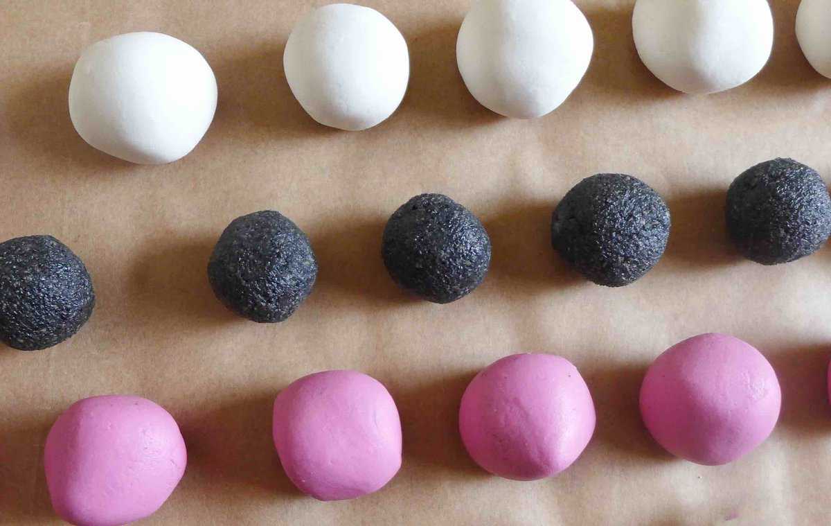 White and pink dough balls and black sesame paste balls.