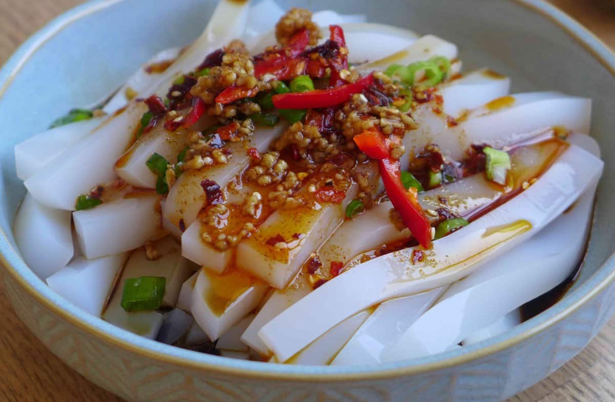 Seasoning and toppings over mung bean jelly noodles.