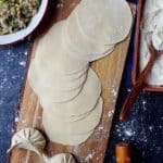 Freshly made dumpling wrappers and two dumplings