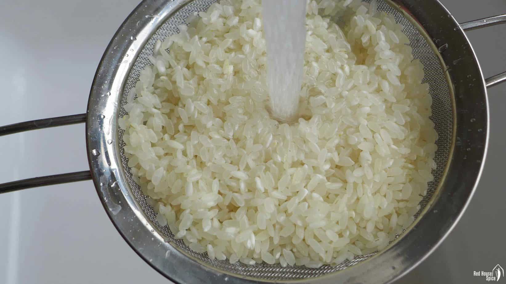 Rinsing rice under running water.