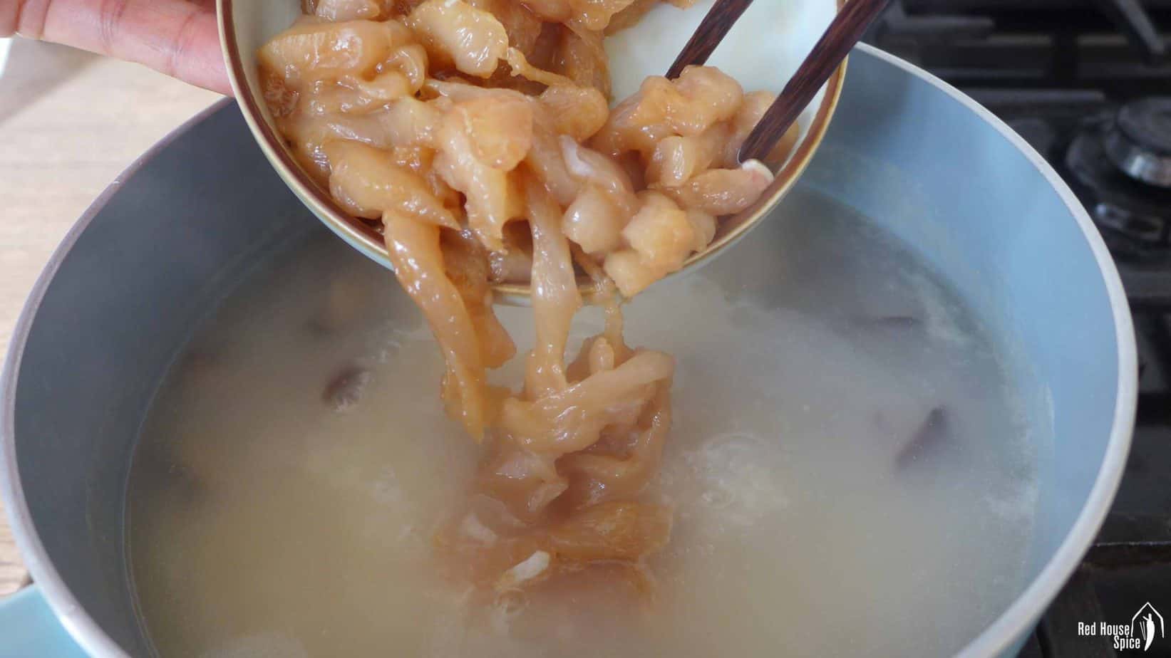 Putting chicken into congee