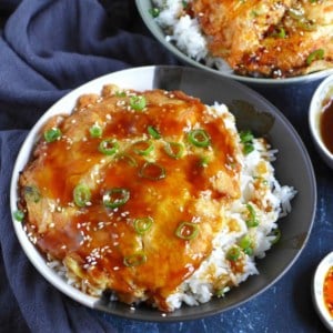 a bowl of rice with egg foo young and brown gravy on top