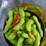 Chinese five spice edamame in a slotted spoon.