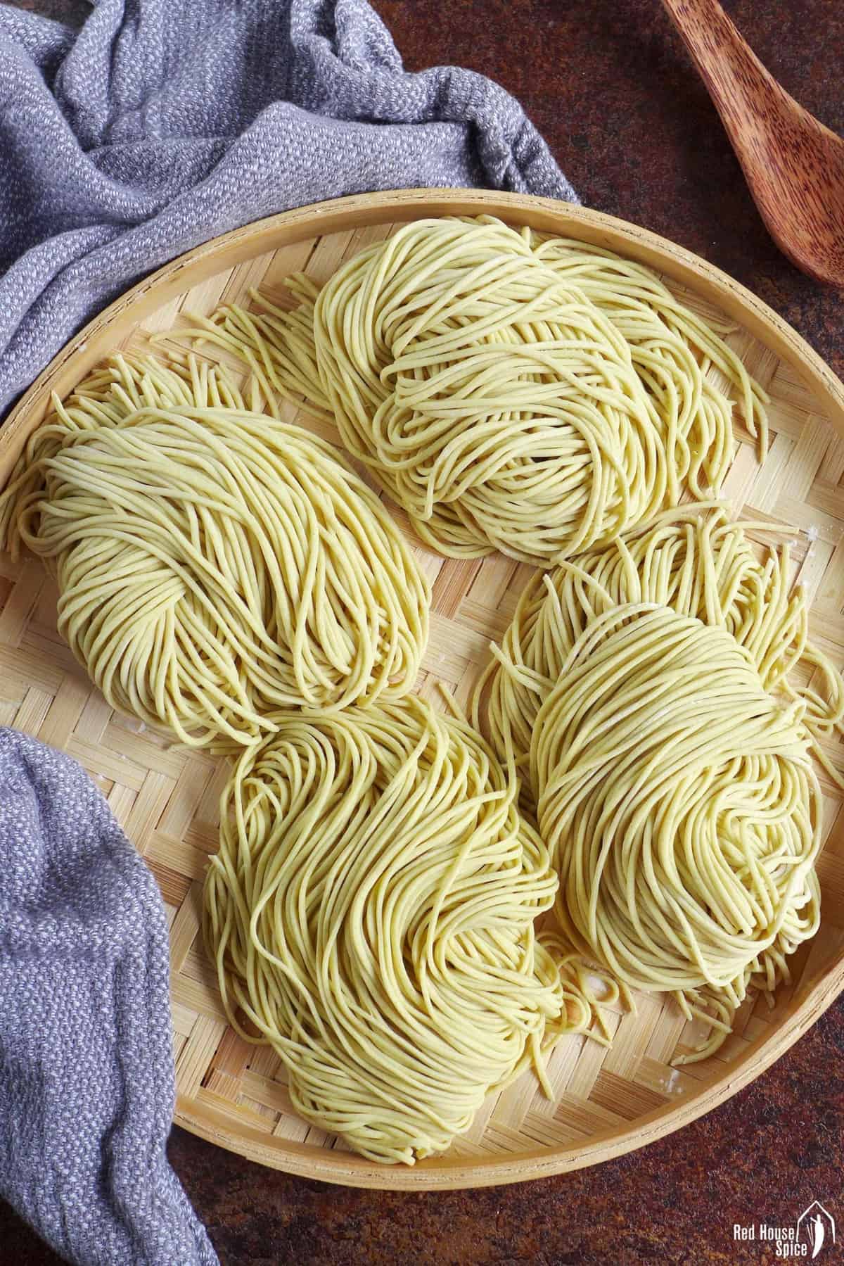 four portions of fresh alkaline noodles on a tray