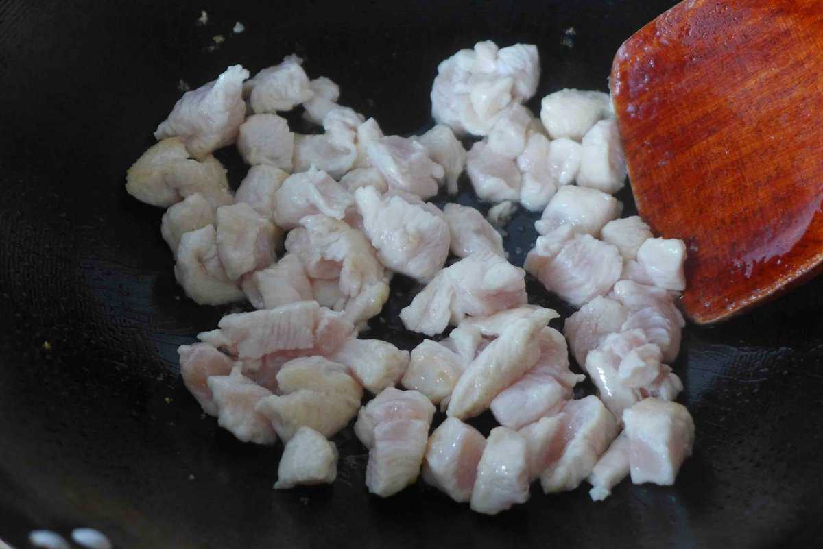 searing chicken pieces in a skillet.