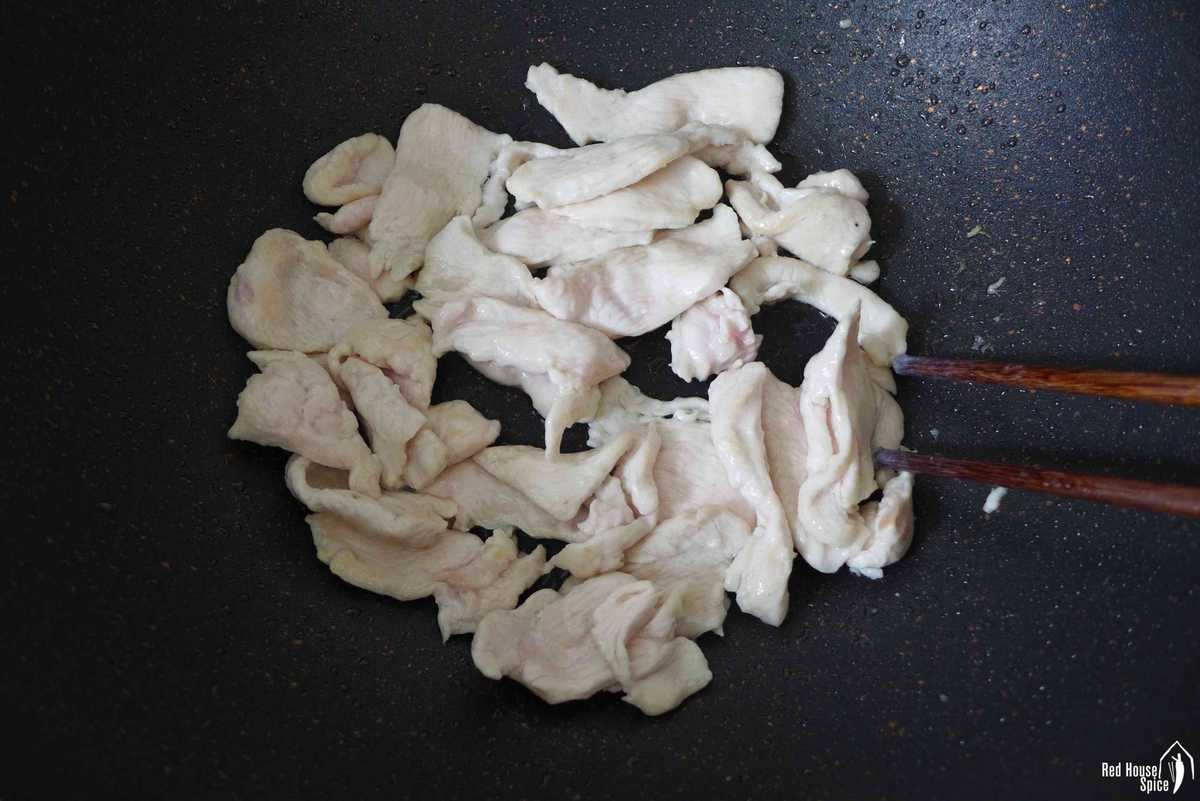 frying chicken slices in a wok