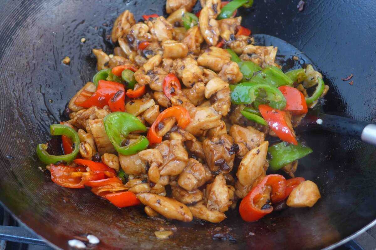 stir-frying chicken with chili pepper.
