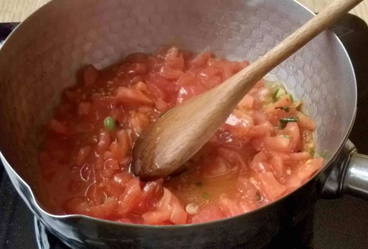 Frying chopped tomato.