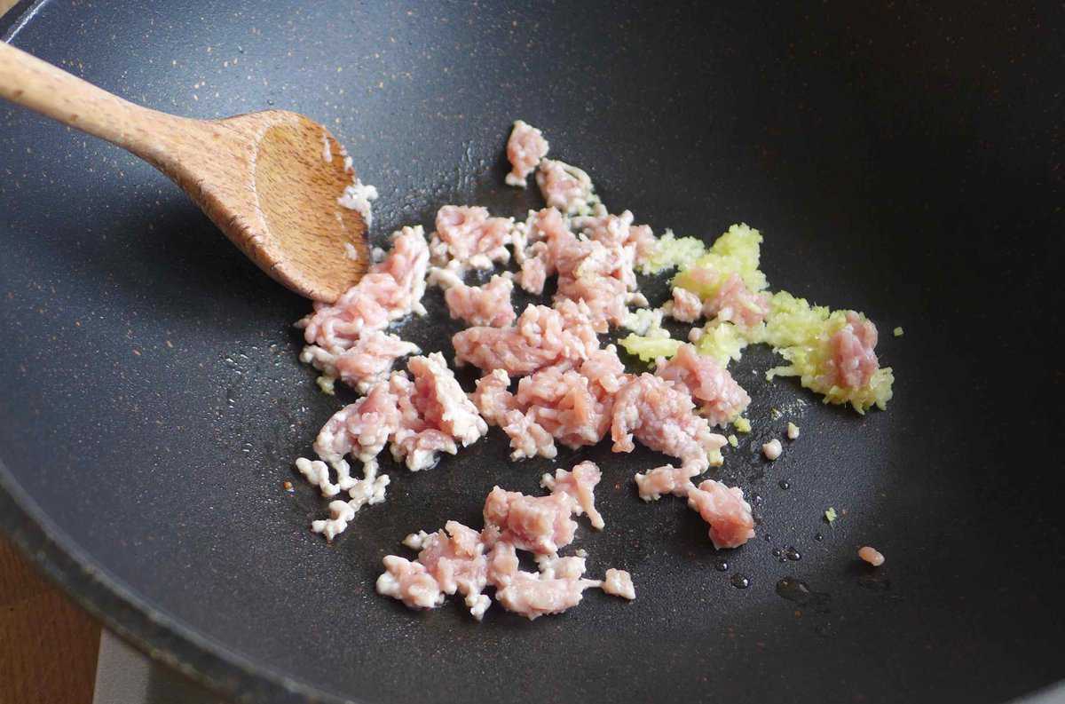 ground pork, ginger, garlic in a wok.