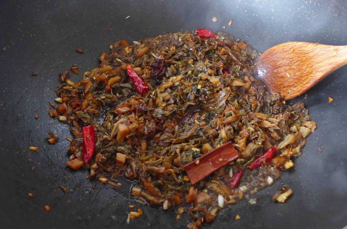 stir-frying Mei Cai with spices.