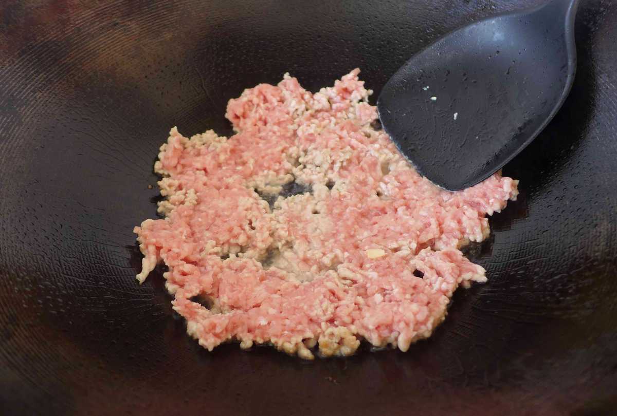 frying minced pork in a wok