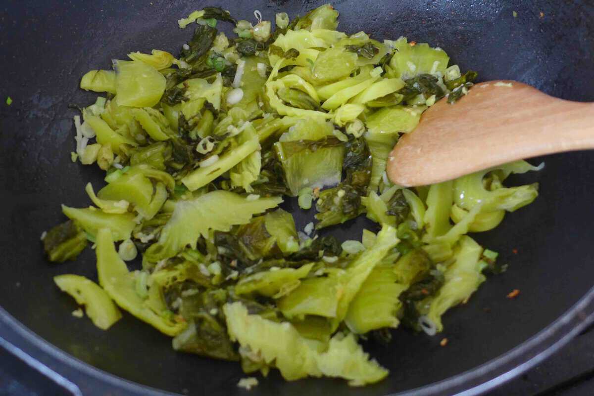 stir frying pickled mustard greens with aromatics.