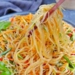 Lifting glass noodles with chopsticks.